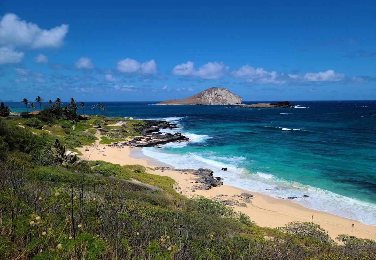 Makapuu Beach with its golden sand, the lighthouse headland and Rabbit Island offshore