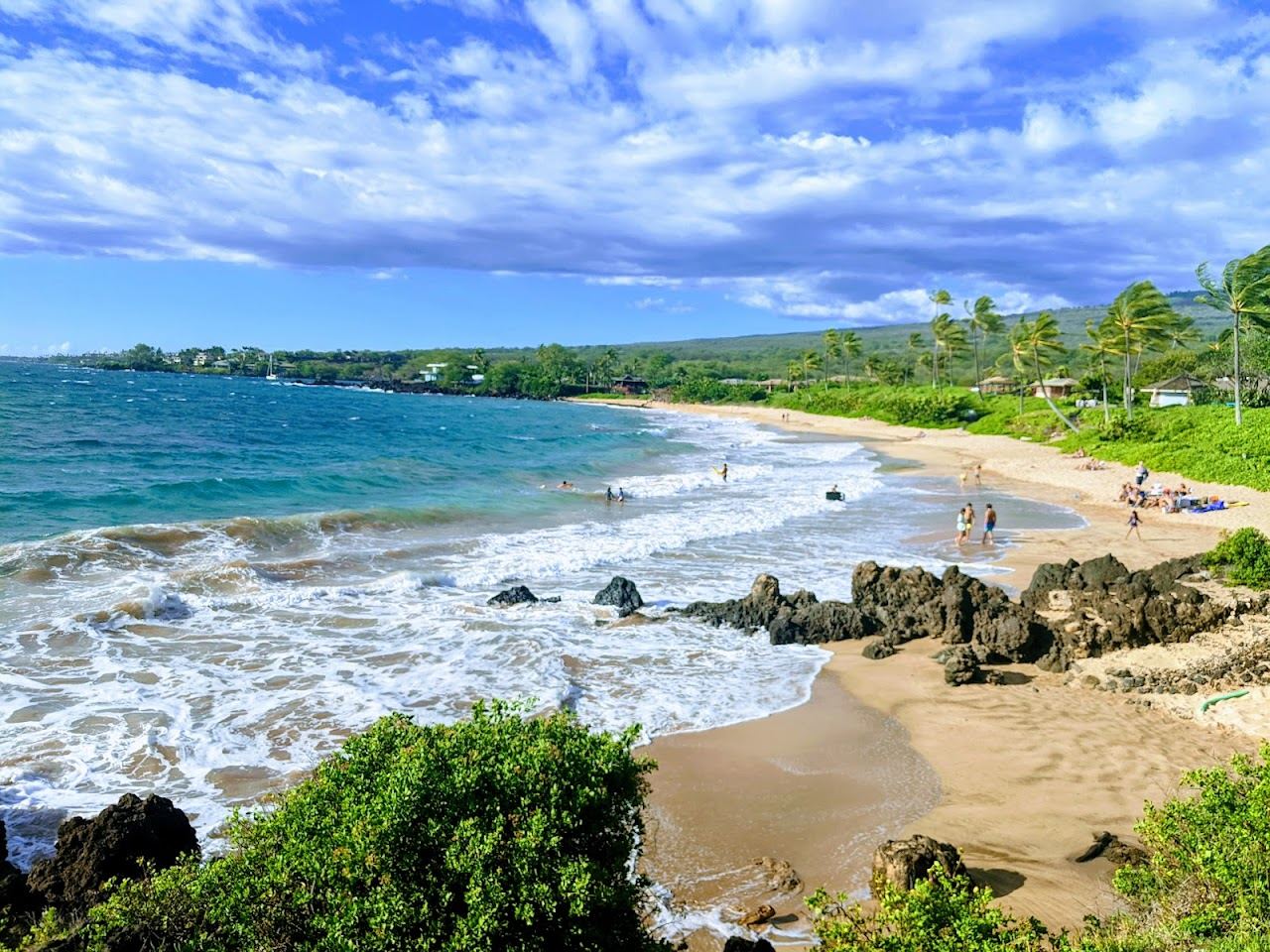 Maluaka Beach at Makena South Maui a curve of golden sand with calm clear water and a rocky reef point at one end