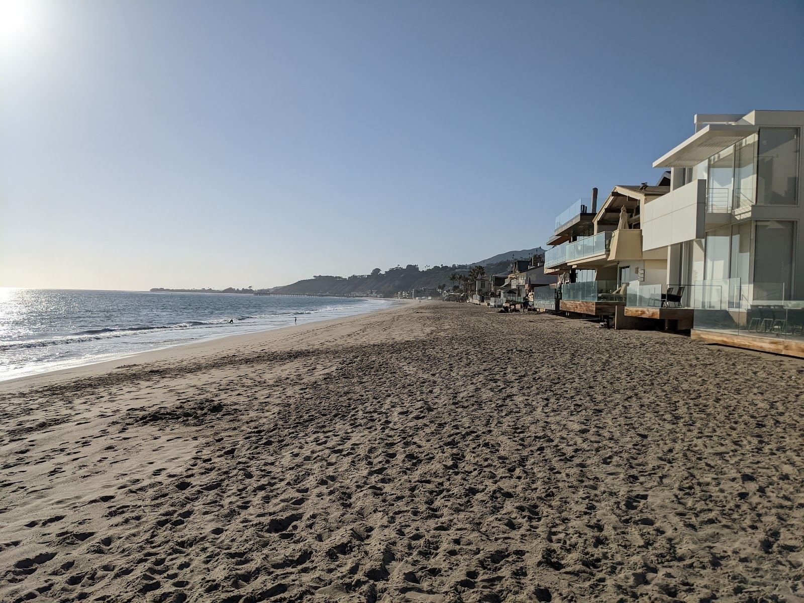 Waves and golden sand along Carbon Beach below the homes of Malibu, California