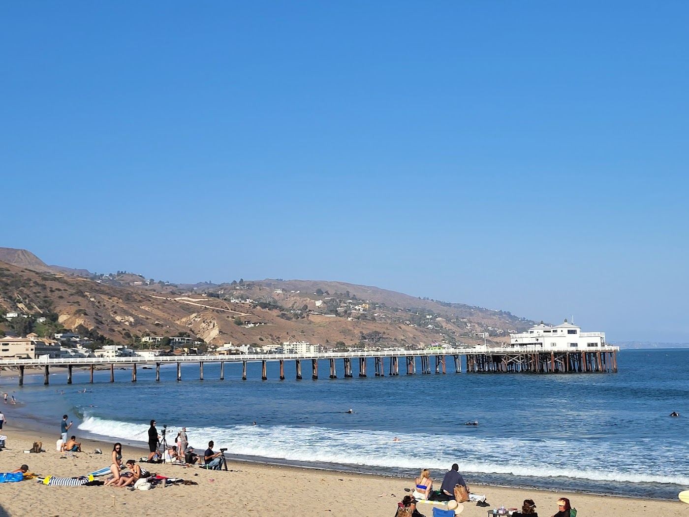 Surfers riding the point break at Surfrider Beach beside Malibu Pier