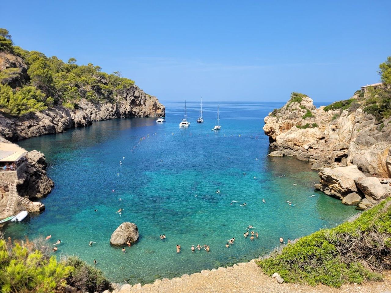 Small rocky cove with deep clear water at Cala Deia below the Tramuntana mountains Mallorca