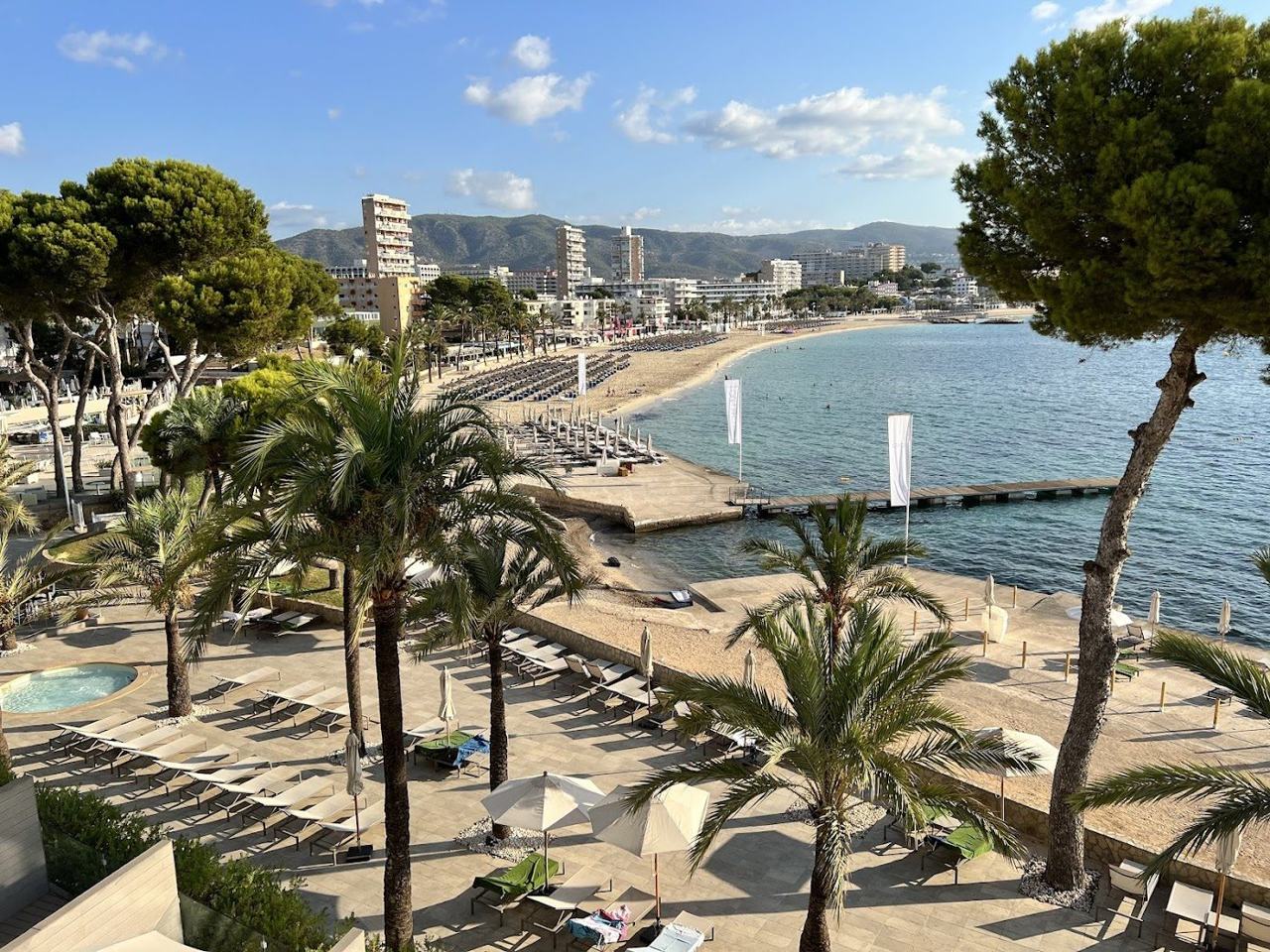 Wide sweep of sand and clear shallow water at Magaluf beach in Mallorca