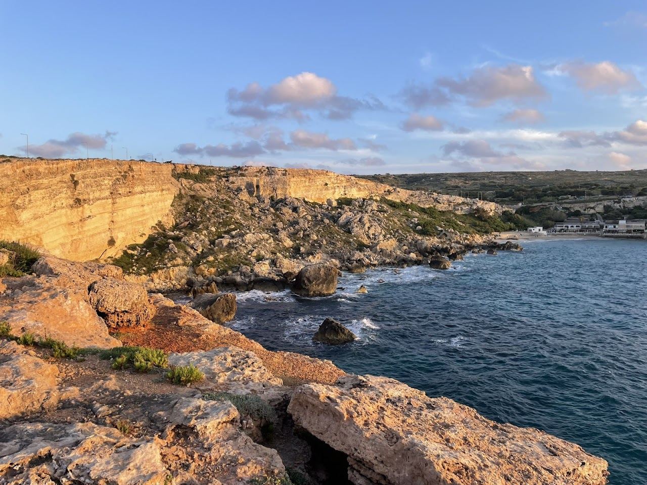Sunset over the western sea from a sandy bay on the northwest Riviera coast of Malta