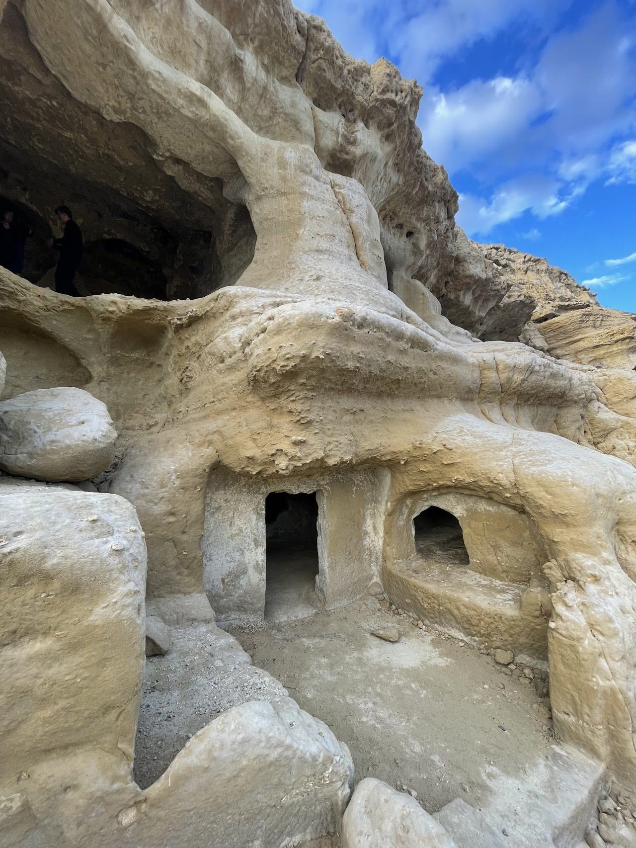 Sandstone cliff caves above the sandy bay at Matala on the south coast of Crete