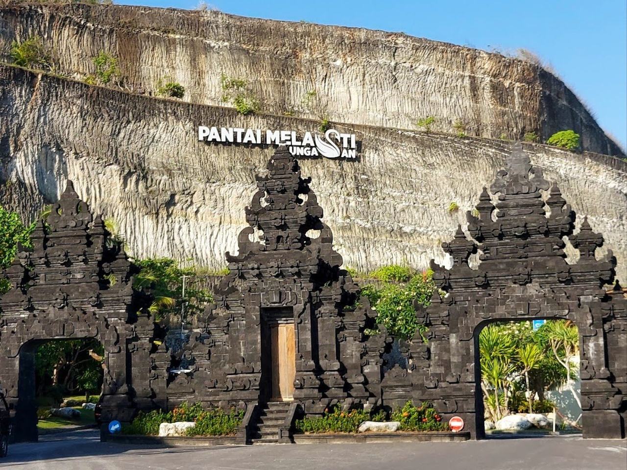 The carved cliff road and white sand shoreline of Melasti Beach in Ungasan Bali