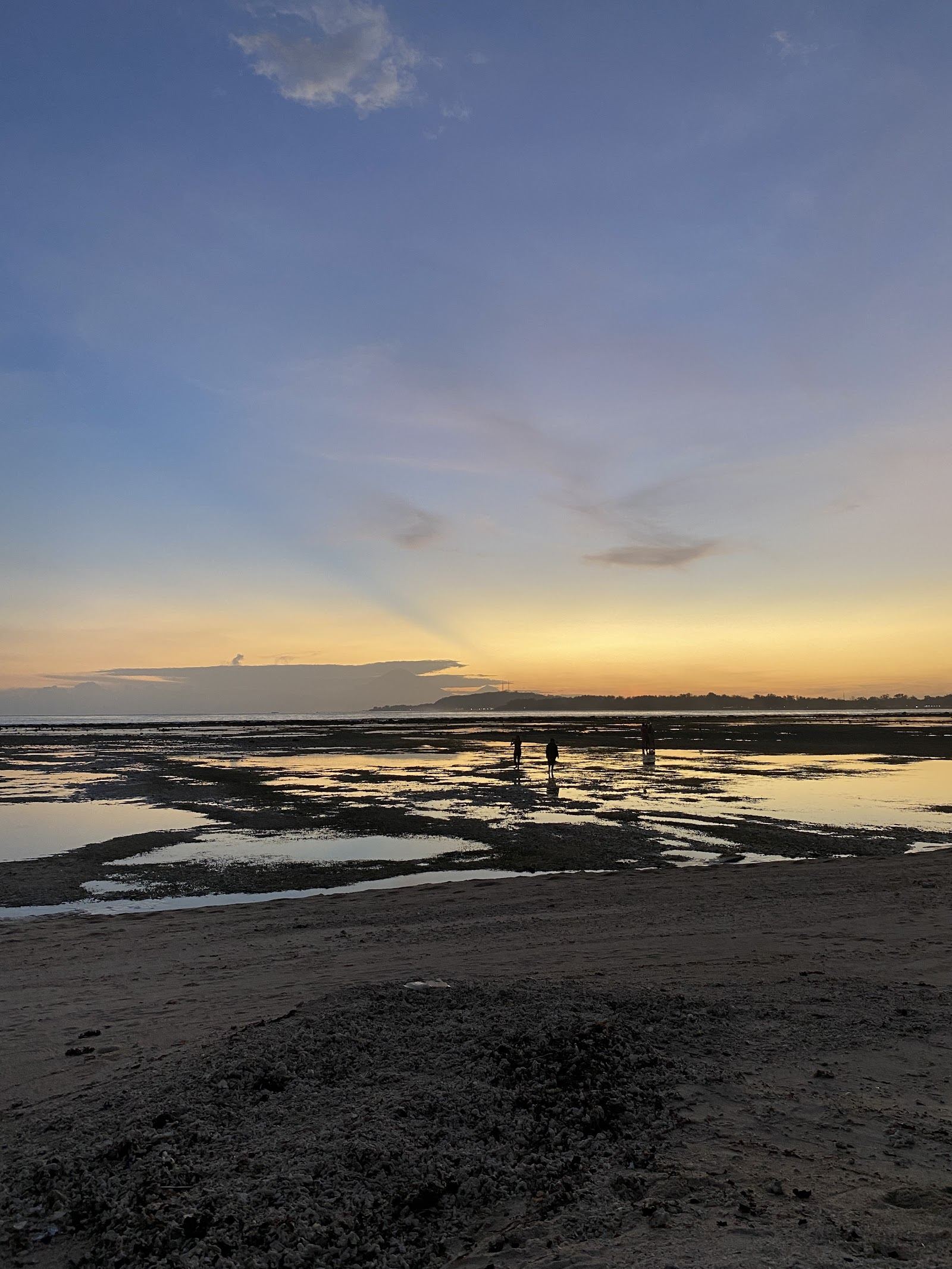 Still water and pale sand at sunset on the west shore of Gili Meno