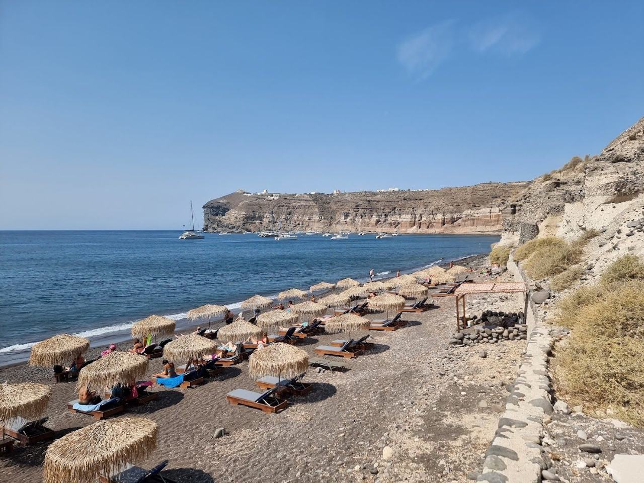 Sun loungers and the family taverna below the cliffs at Mesa Pigadia Beach
