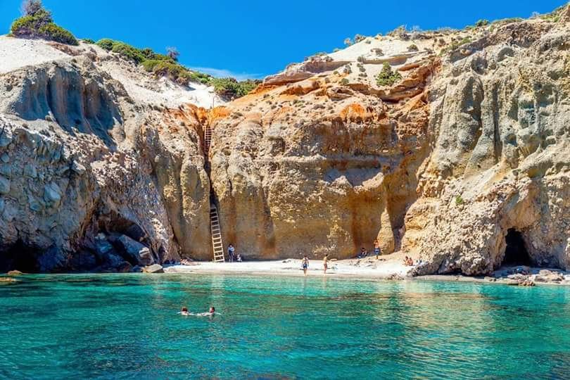 Turquoise water and pale cliffs along a Milos beach in the Cyclades
