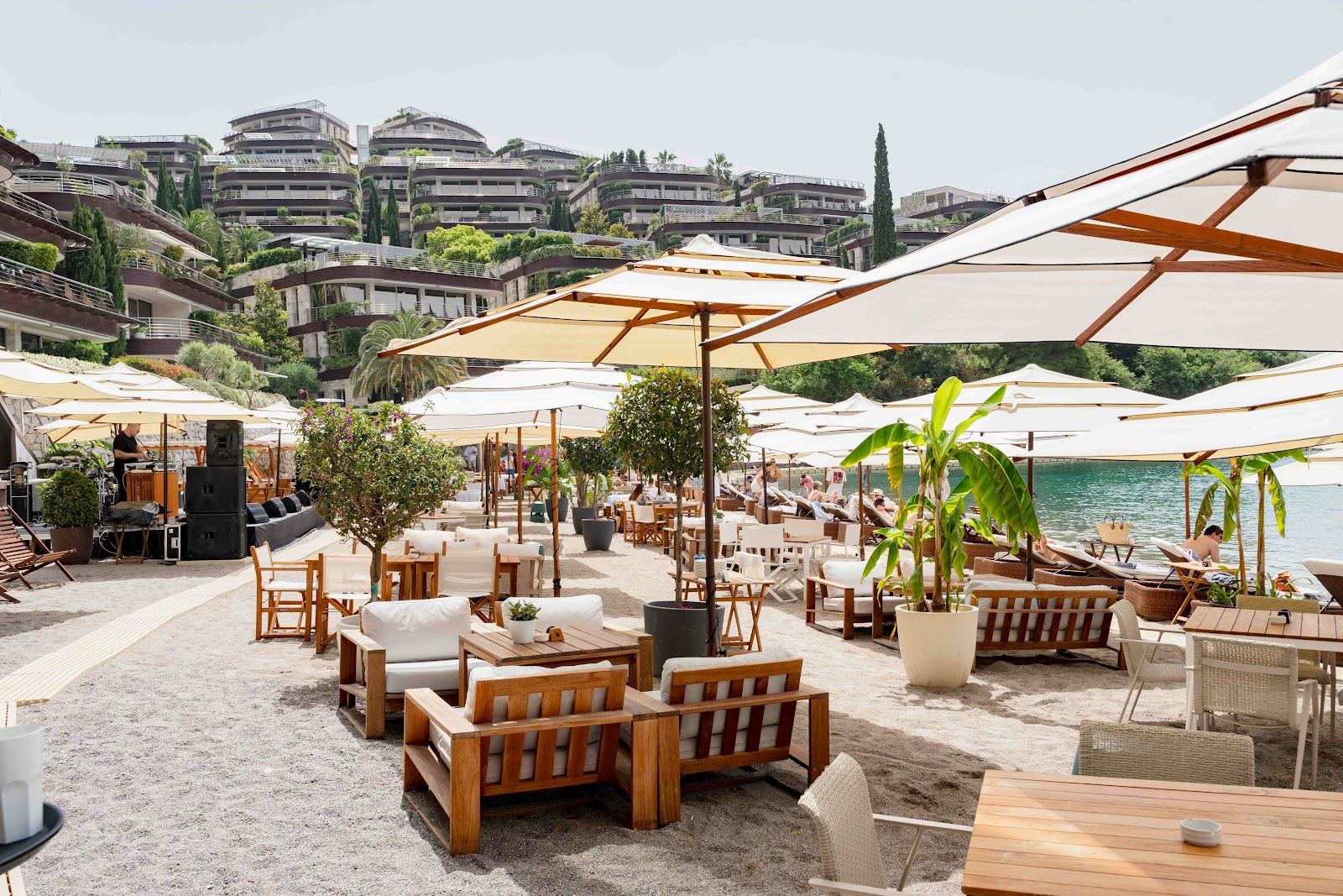 Loungers on a platform beach club above the clear Adriatic on the Montenegro coast