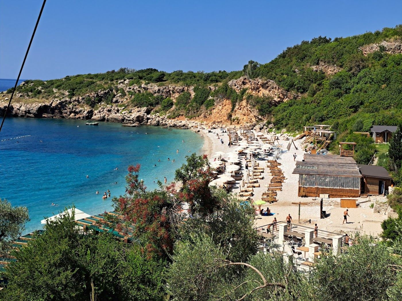The secluded sandy cove of Drobni Pijesak backed by green hills on the Montenegro coast