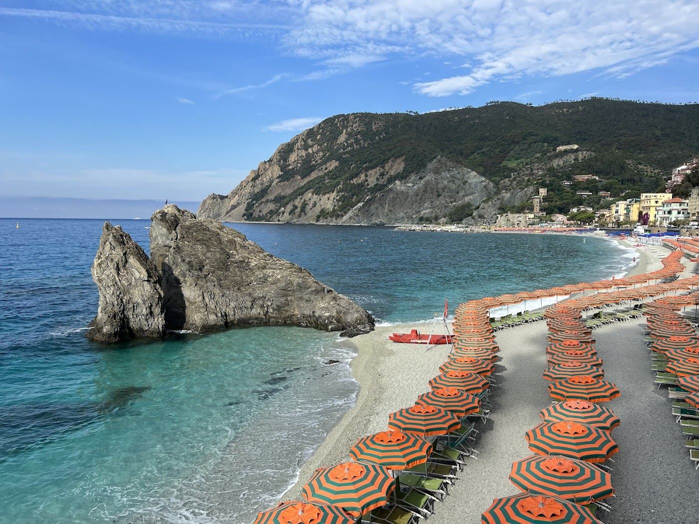 The long sandy Fegina beach with hired umbrellas below the pastel houses of Monterosso al Mare