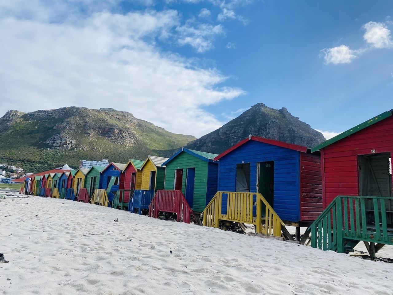 The long surf beach and colourful Victorian bathing boxes of Muizenberg on False Bay in Cape Town