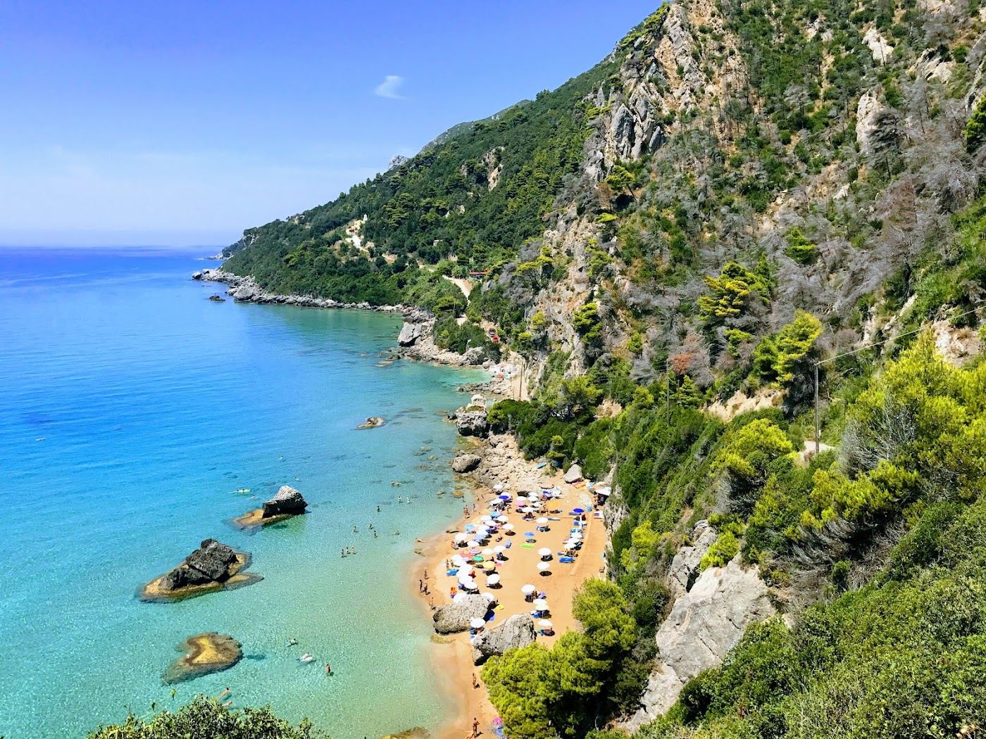 The secluded cove and green cliffs at Myrtiotissa on the west coast of Corfu