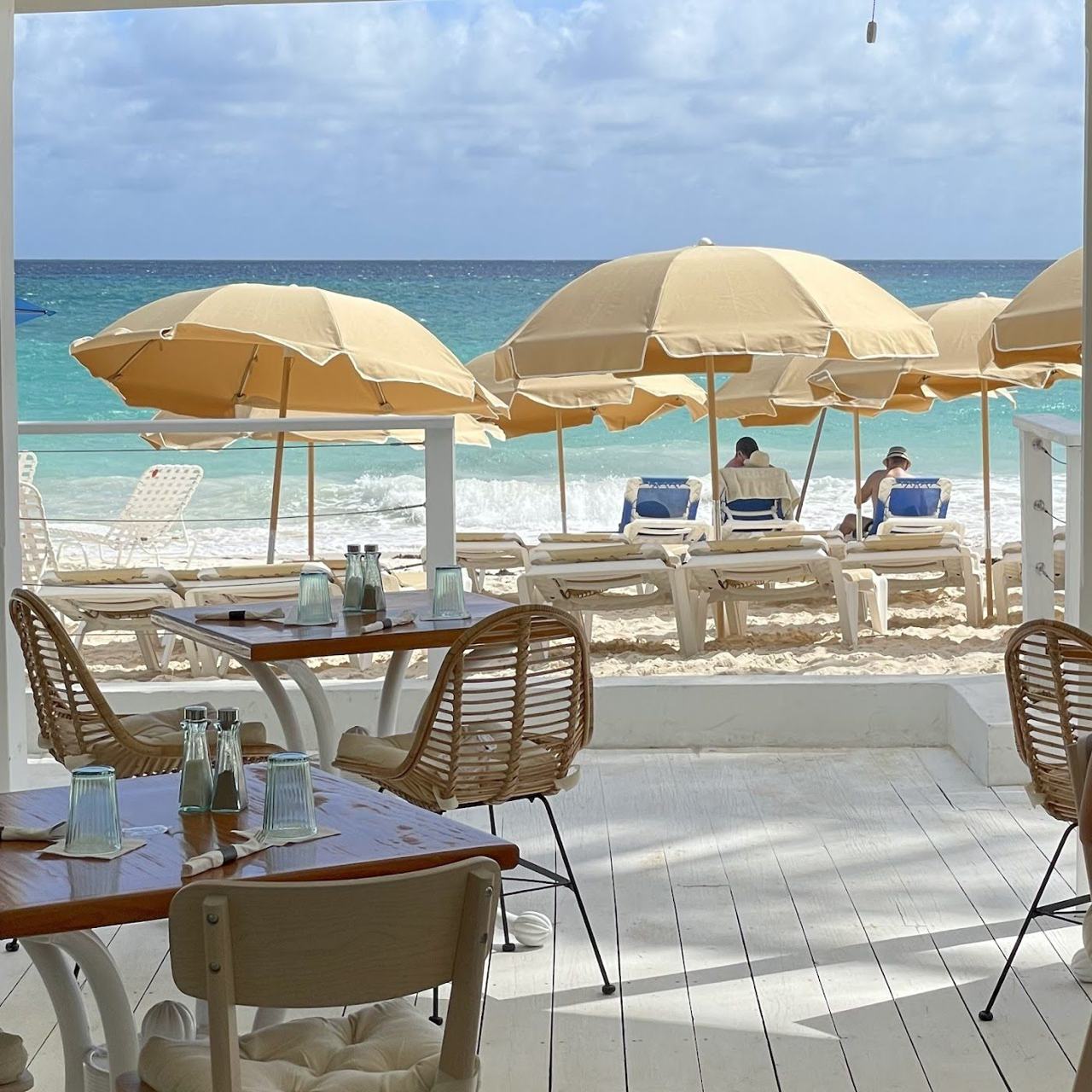 A stylish newer beach club with loungers and turquoise water on the Barbados south coast