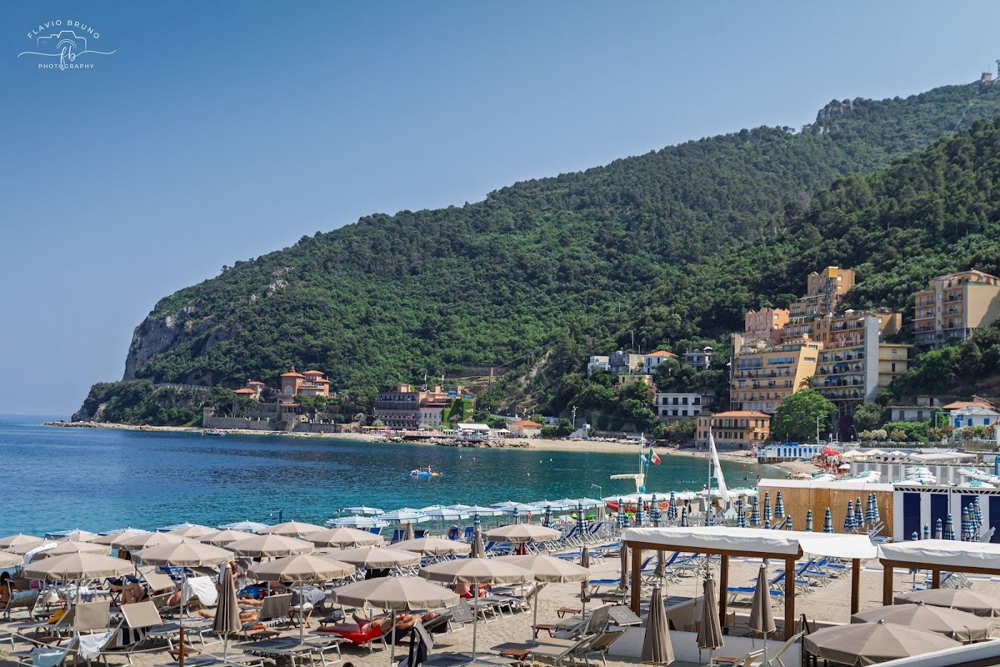 The medieval town of Noli rising behind its sandy Ligurian beach
