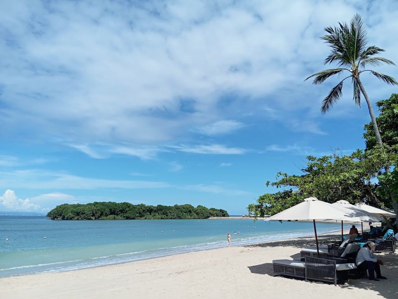 Calm reef sheltered water and white sand backed by palms at Nusa Dua Beach in Bali