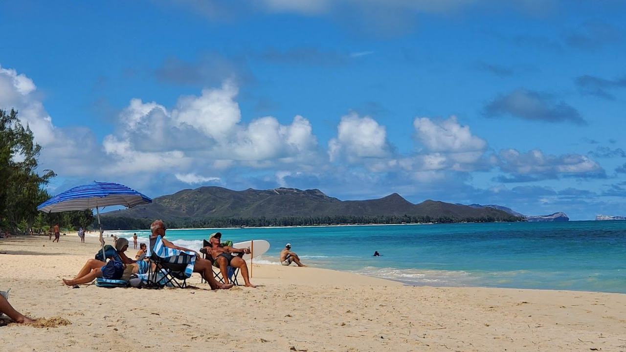 Soft sand and gentle turquoise water along the quiet windward coast of Oahu Hawaii at golden hour