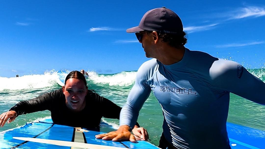 Surfers and longboards in the gentle waves off Waikiki Beach with Diamond Head behind on Oahu Hawaii