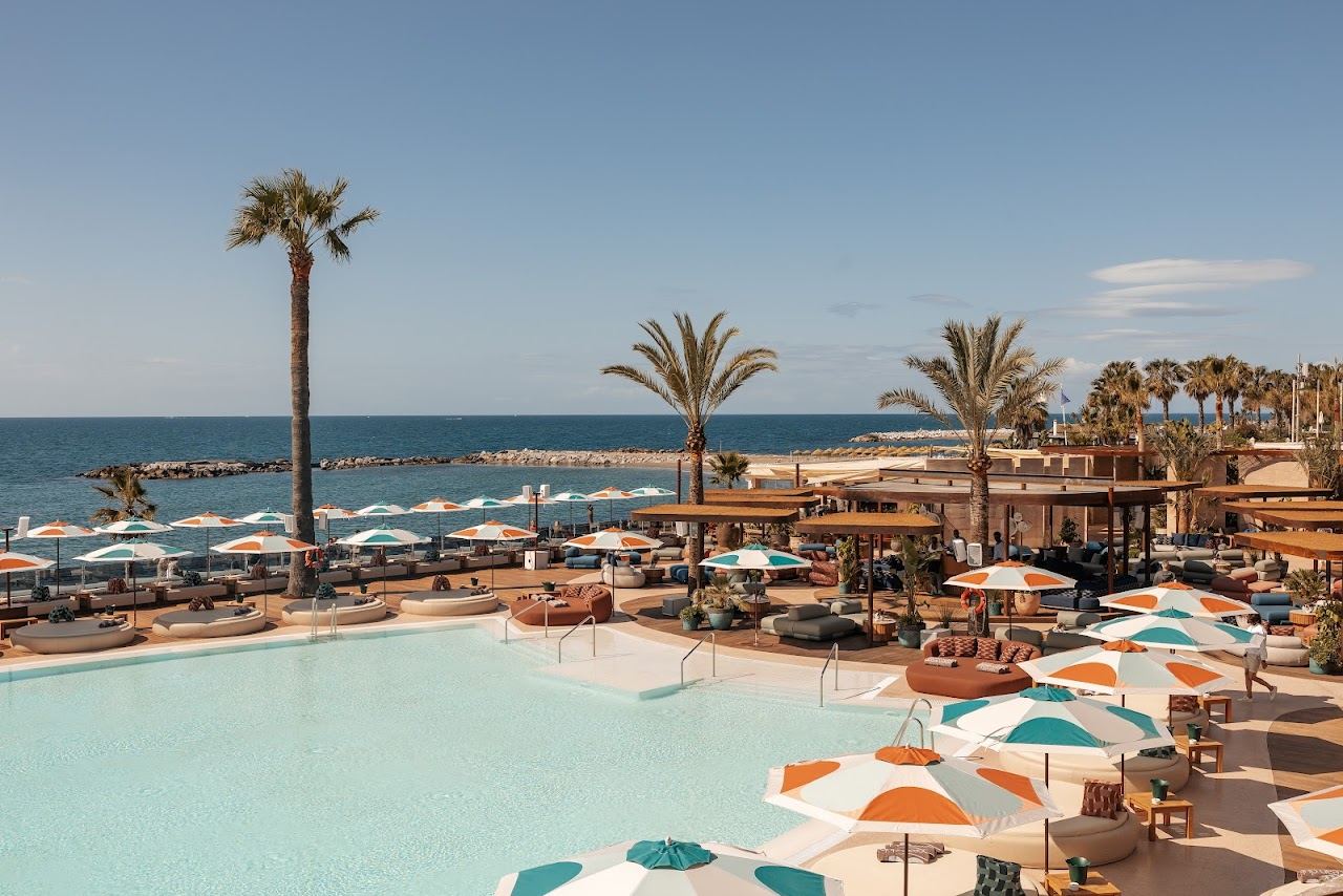 White day beds arranged around the saltwater pool at Ocean Club Marbella in Puerto Banus
