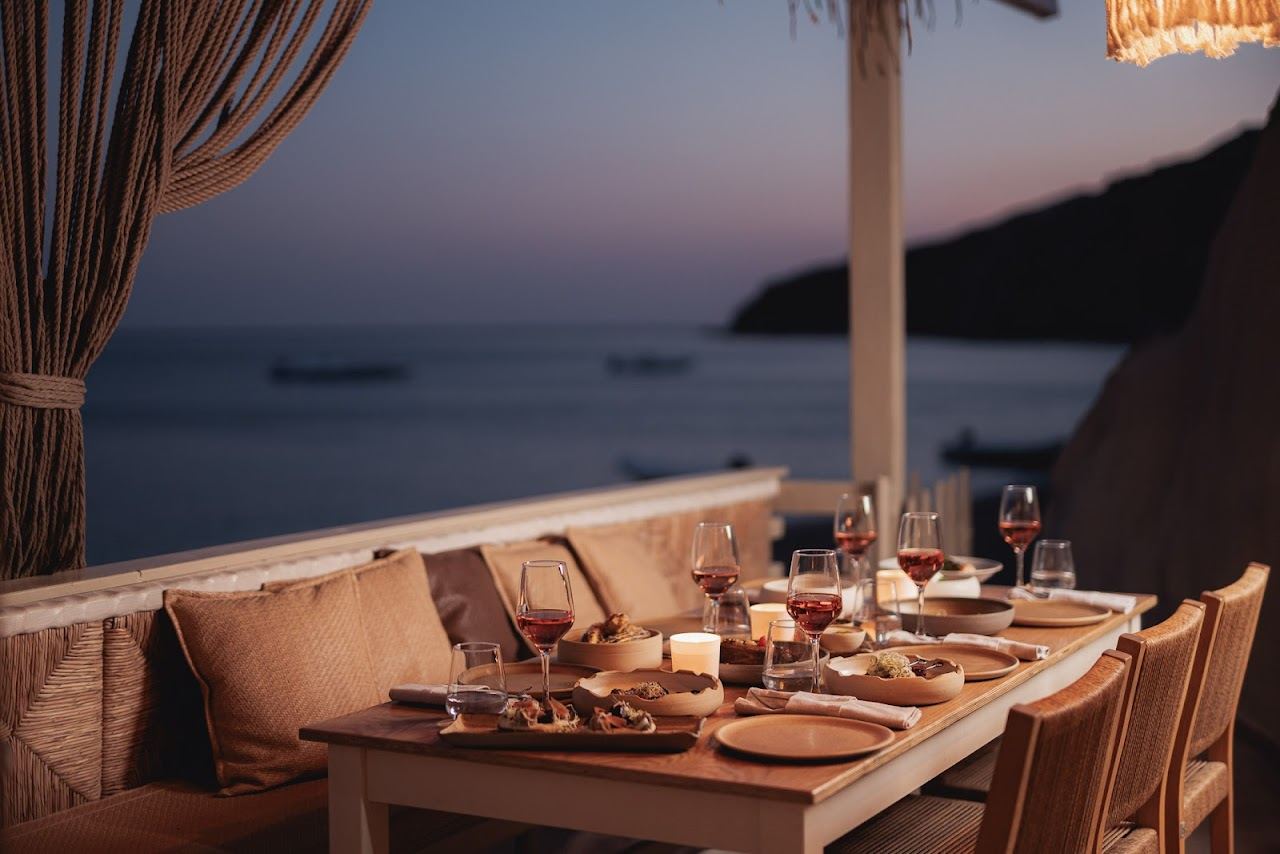 Tables on the sand at Sirocco on Paliochori beach where food is cooked in the warm volcanic ground on the south coast of Milos