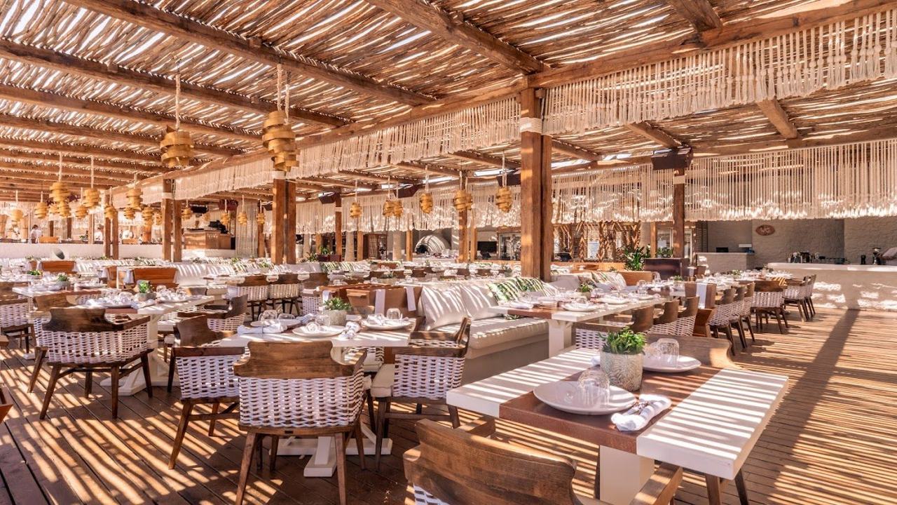 Daybeds and a bohemian beach club setting on the sand at Panormos on Mykonos