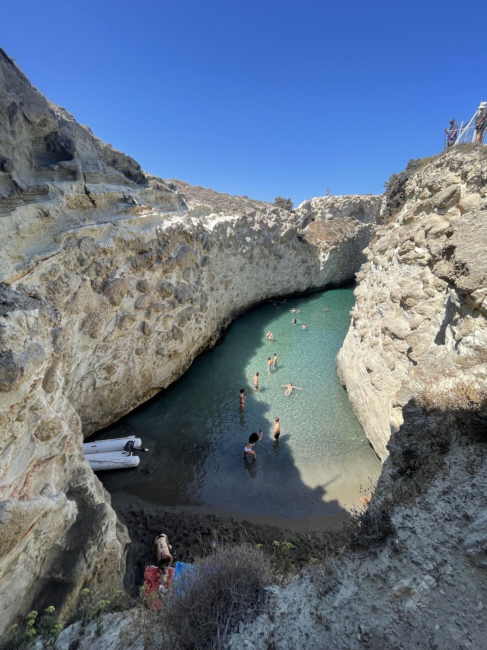 The narrow turquoise inlet of Papafragas carved between sheer volcanic cliffs on the north coast of Milos