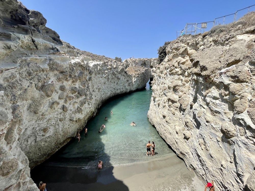 The clear turquoise channel and sea caves of Papafragas seen from the cliff viewpoint near Pollonia on Milos