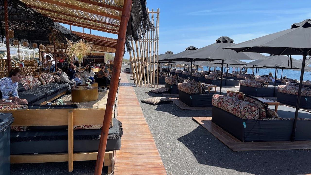 A beach club lounge and day beds on the black sand at Perivolos on Santorini