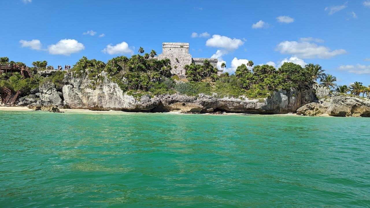 Soft white sand, wooden fishing boats and turquoise Caribbean water at Playa Pescadores in Tulum
