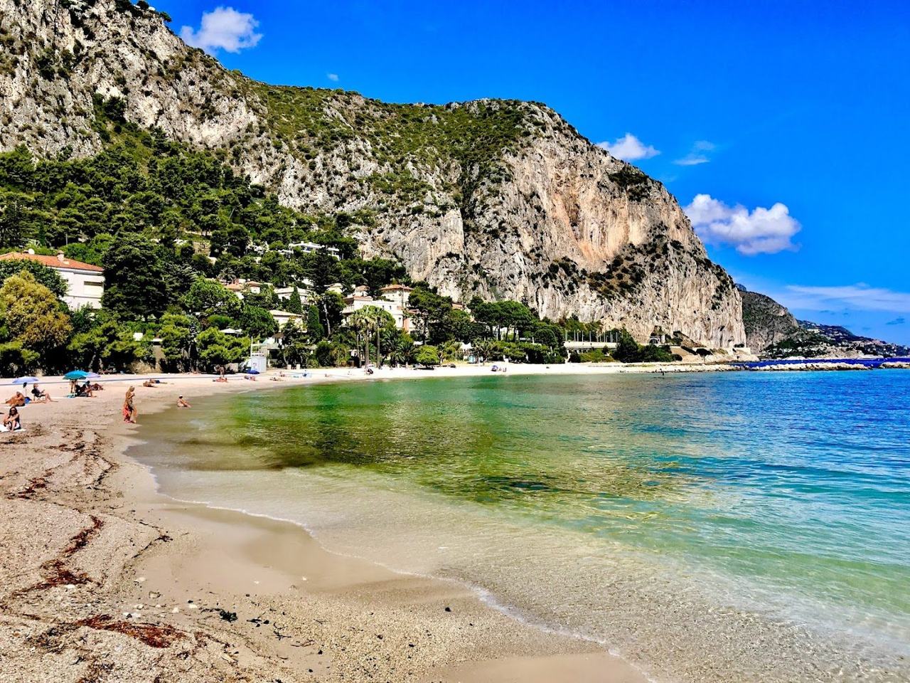 Sheltered pebble beach and calm clear water at Petite Afrique in Beaulieu sur Mer