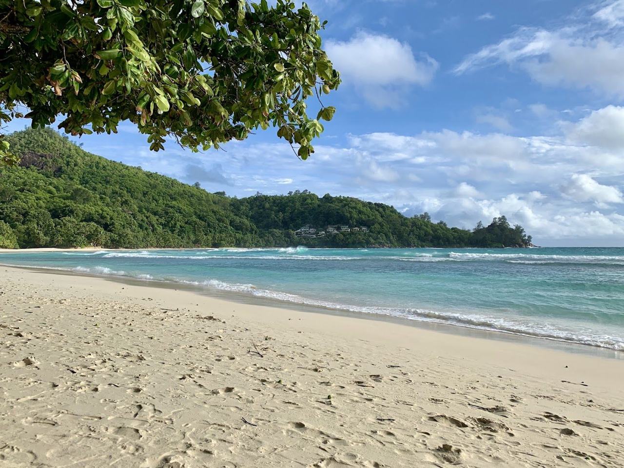 Forested hills around the calm bay at Petite Anse on south west Mahe