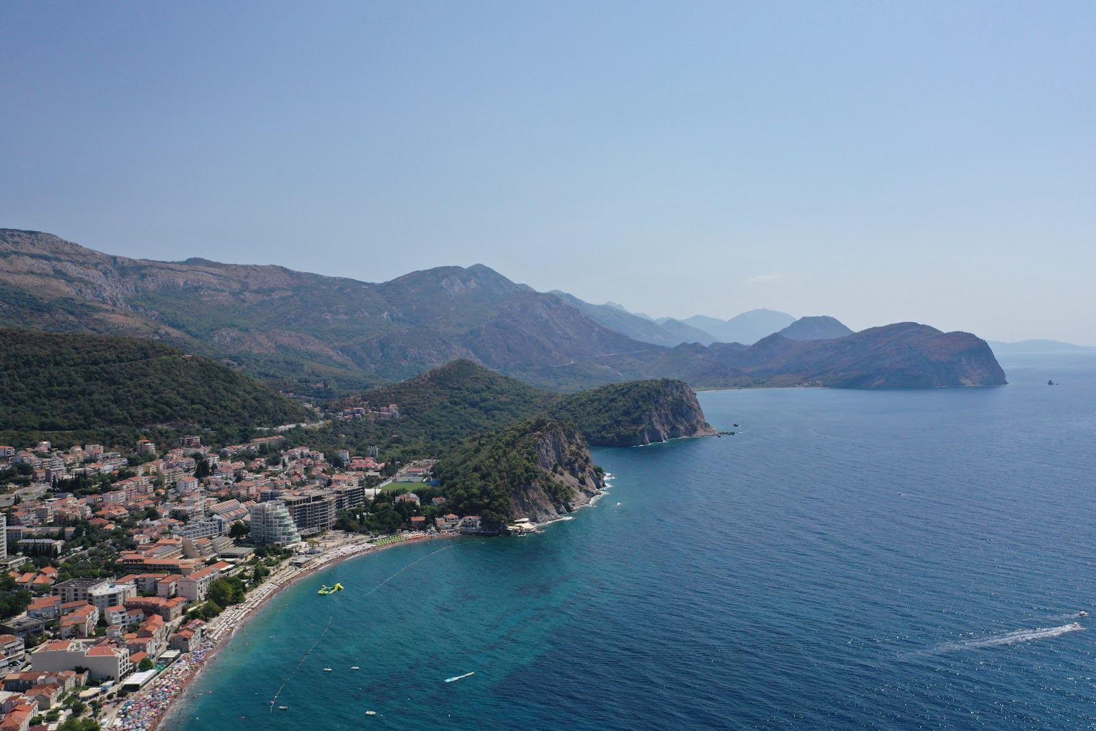 Petrovac reddish sand town beach with two islets offshore in Montenegro