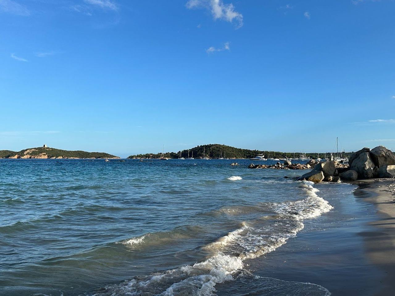 The long pale sand and shallow calm bay at Pinarello village north of Porto Vecchio in Corsica