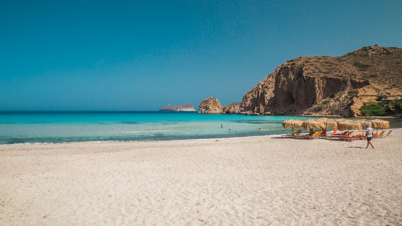The sheltered sandy bay of Plathiena with calm clear water and tamarisk trees near Plaka on the northwest coast of Milos