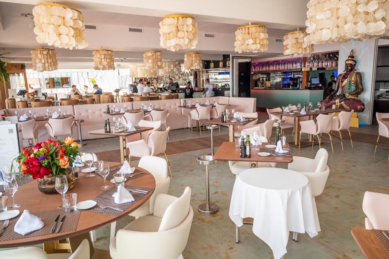 Sunbeds and beach club daybeds lining the wide golden sand of Playa d'en Bossa in southern Ibiza