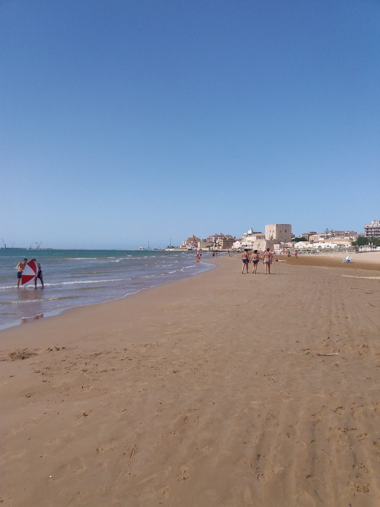 Long broad sandy town beach and shallow water at Pozzallo on the southern coast of Sicily