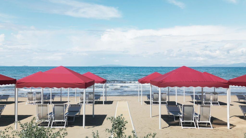 The fine golden sand and calm bay of Punta Ala backed by pinewoods on the Maremma coast of Tuscany