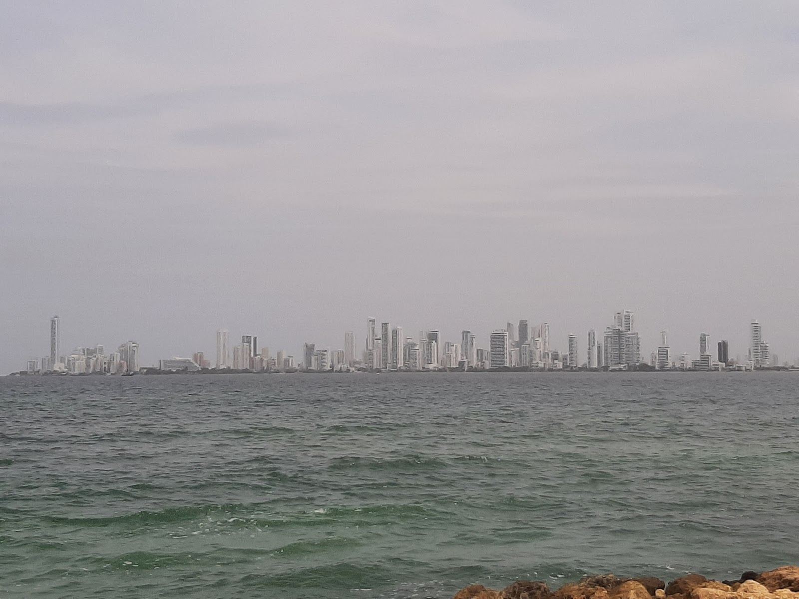 Pale sand and calm water at Punta Arena on Tierra Bomba island with the Cartagena skyline across the bay