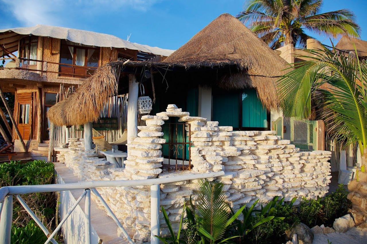 White sand meeting low rock shelves and turquoise water at Punta Piedra in the Tulum hotel zone