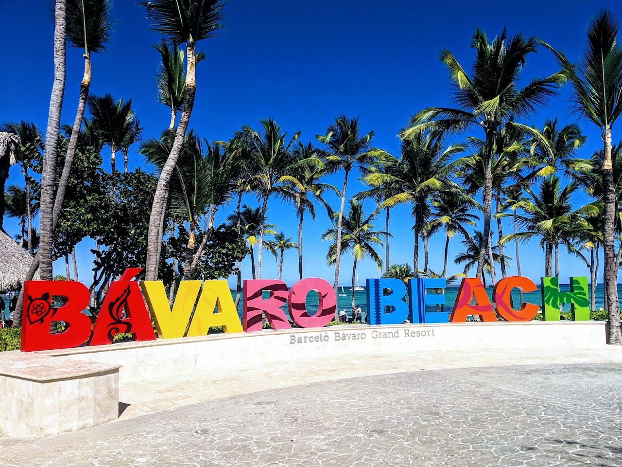 Wide free public stretch of pale sand and calm turquoise water on Bavaro Beach in Punta Cana