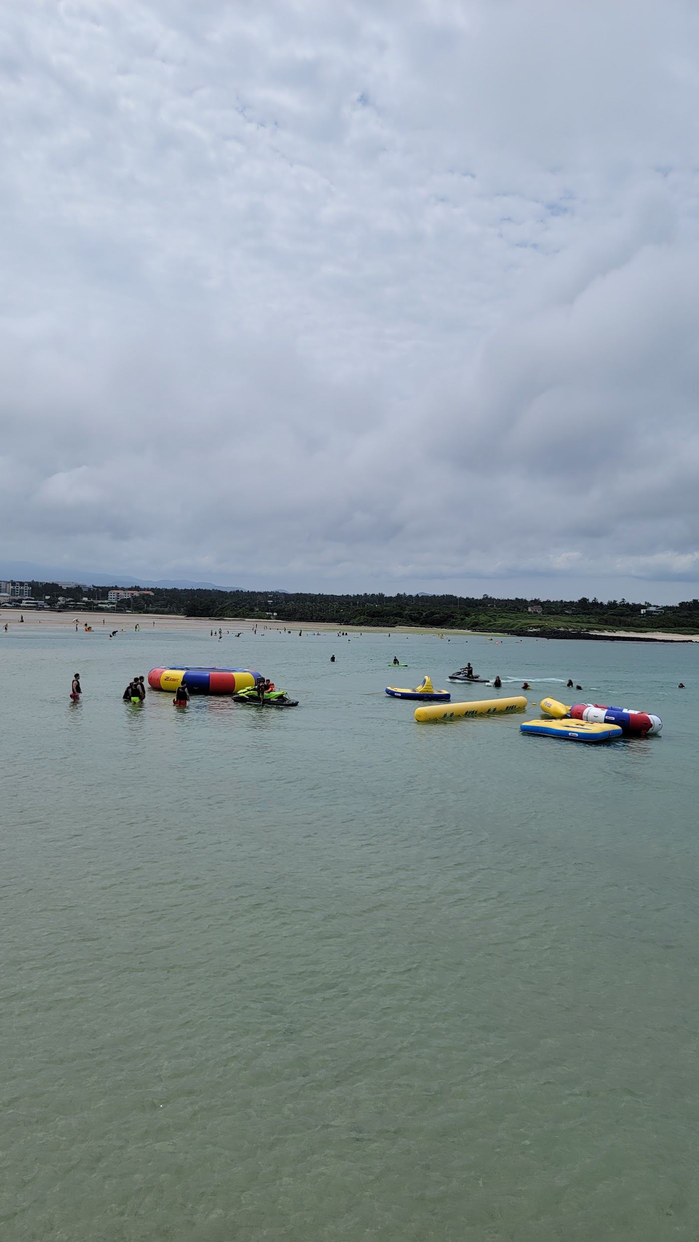 The wide shallow tidal lagoon and pale sand at Pyoseon Beach on the Jeju southeast coast
