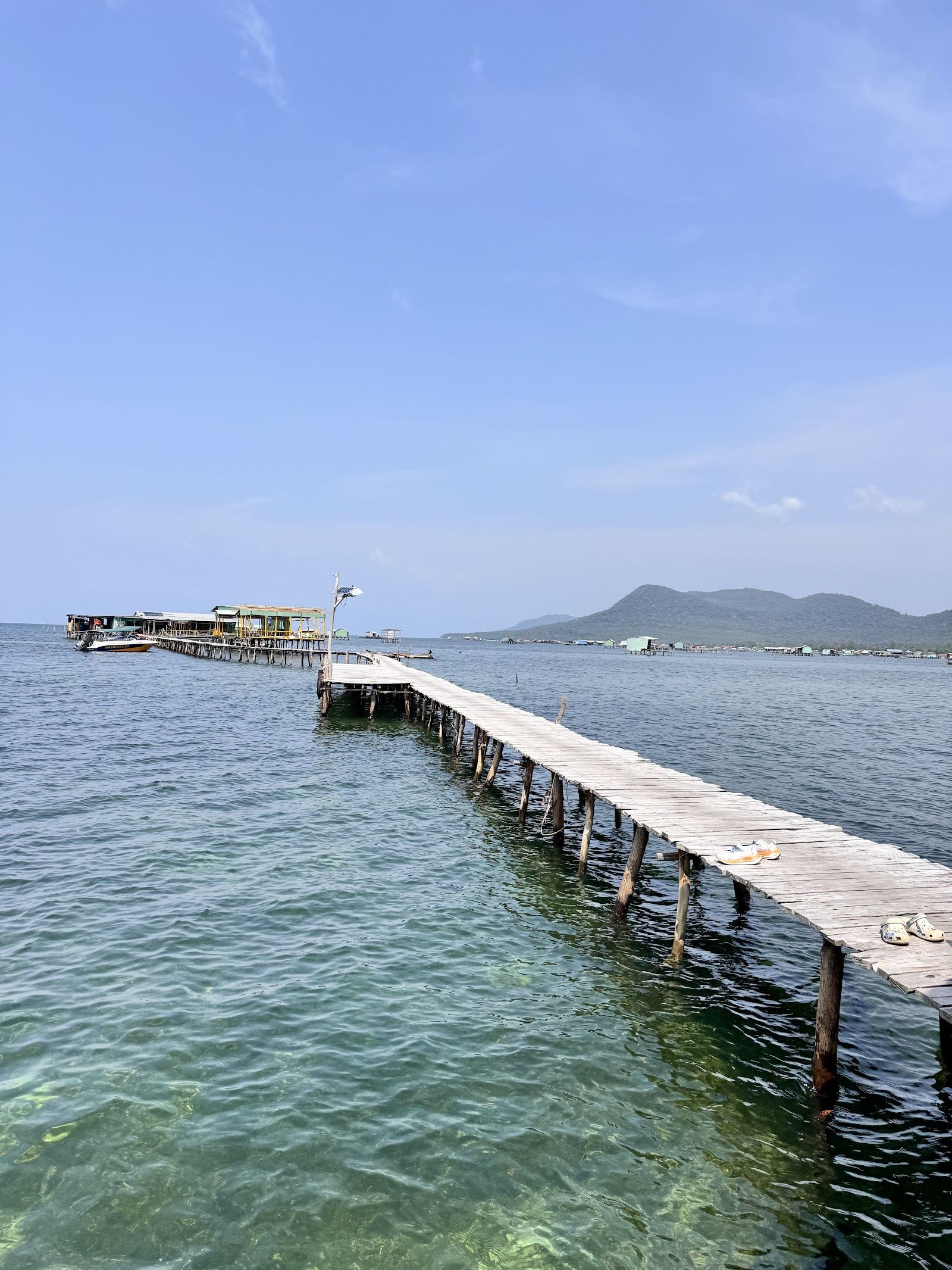 Weathered stilt houses and moored fishing boats over the calm shallow Ham Rong bay at Rach Vem village on the north coast of Phu Quoc