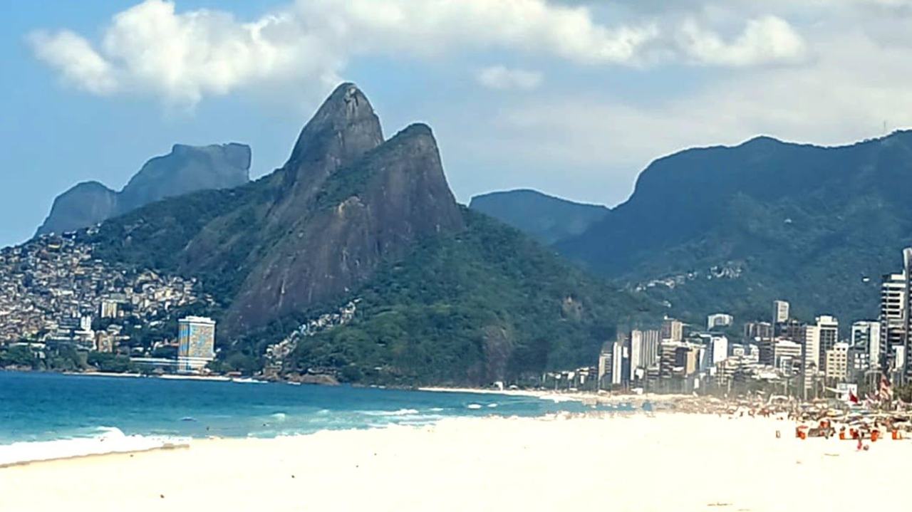 The calmer upscale sand of Leblon Beach with the Two Brothers mountain in Rio de Janeiro
