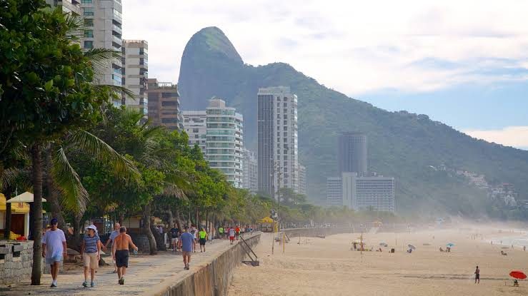 Hang gliders landing on Sao Conrado beach below the towering Pedra da Gavea in Rio de Janeiro