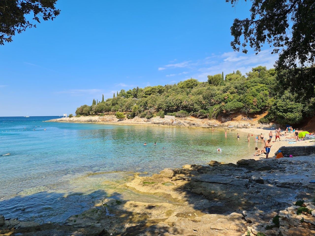 Pebble and gravel bay with a lively bar mood at Saccorgiana on the Verudela peninsula near Pula