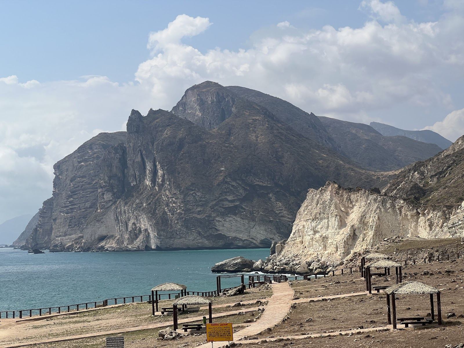 Dramatic cliffs and clear Arabian Sea water at Al Mughsail Beach near Salalah in Oman