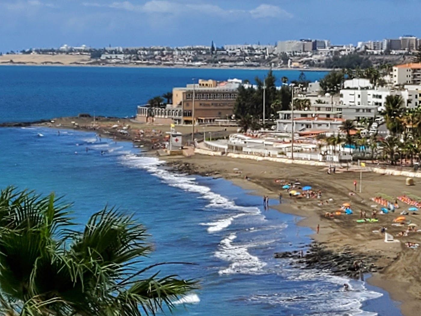 Dark gold sand and low rise resort behind the beach at San Agustin in southern Gran Canaria