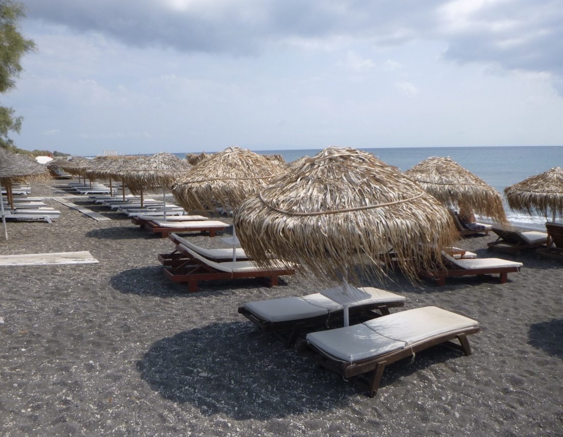 The long organised black sand of Perivolos beach on the southeast coast of Santorini