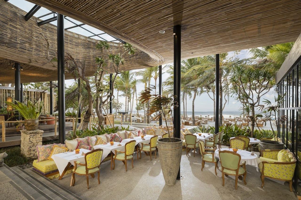 Loungers and bar by the calm sea at Byrdhouse Beach Club in Sanur Bali
