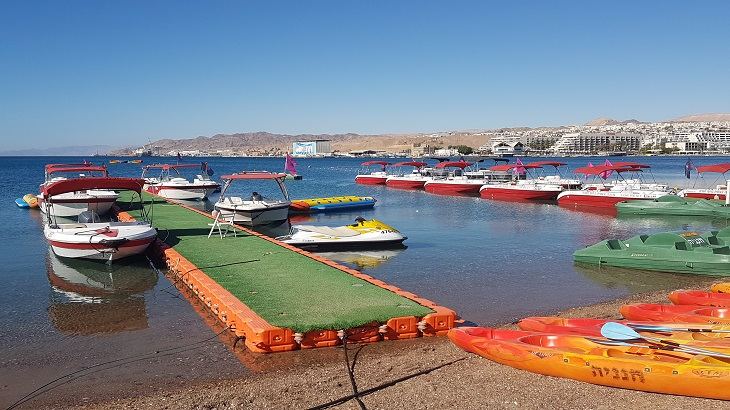 The northern shore sand and swimmers near Seagulls Beach in Eilat